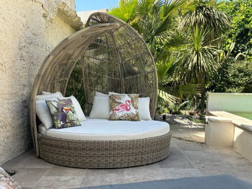 einen Korbschaukelstuhl auf einer Terrasse in der Unterkunft un petit coin de paradis avec piscine et parking in Villeneuve-lès-Avignon