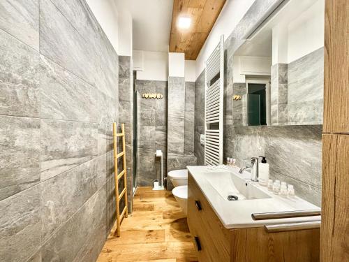 La salle de bains est pourvue d'un lavabo et de toilettes. dans l'établissement Moderno TRILOCALE vicino alle piste, à San Pietro