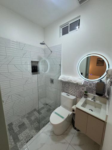 a bathroom with a toilet and a sink and a mirror at Apartaestudio la capital in San José