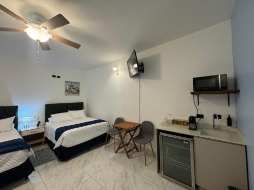 ein Hotelzimmer mit einem Bett, einem Schreibtisch, einem Bett und einem Tisch in der Unterkunft Apartaestudio la capital in San José