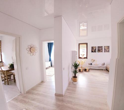 a living room with white walls and a wooden floor at Cozy SoRaDa 1 apartment in Bragadiru
