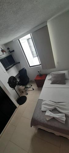 um quarto com 2 camas, uma secretária e uma janela em habitación con baño en bucaramanga-cerca sena-uis em Bucaramanga