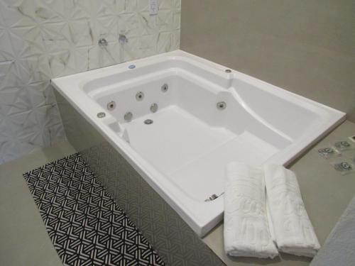 a white bath tub in a bathroom with towels at Pousada Meraki in Serra do Cipo