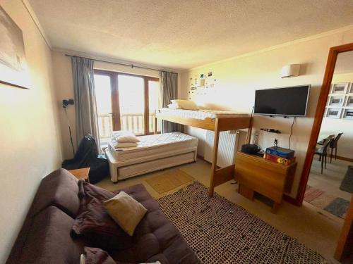 - un salon avec un canapé et un bureau dans l'établissement Apartamento Valle de la Luna 502 - VALLE NEVADO, à Santiago