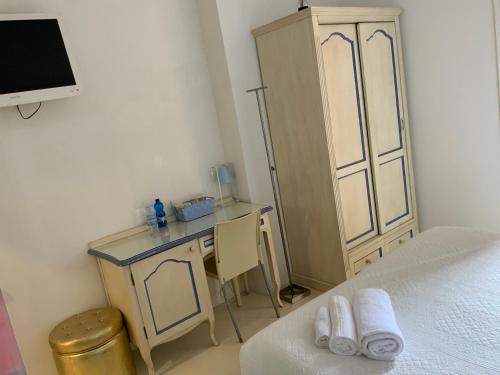 een slaapkamer met een bed, een bureau en een kast bij Domus Dotta in Bologna