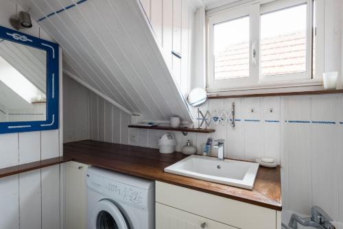 uma casa de banho com uma máquina de lavar roupa e um lavatório em Appartement 2 chambres Bassin d'Arcachon front de mer, plage du Betey em Andernos-les-Bains