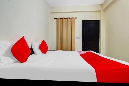 ニューデリーにあるOYO Flagship Hotel B K Palaceの赤と白のベッド(赤の枕付)