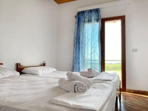 two beds in a room with towels on them at Boem Villas 1 in Lezhë