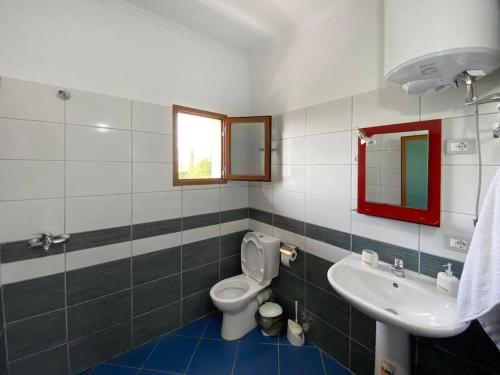 a bathroom with a toilet and a sink at Boem Villas 1 in Lezhë