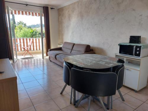 un salon avec une table et un canapé dans l'établissement Studio de La Vigne - Axelle Loc'Appart, à Mandelieu-la-Napoule