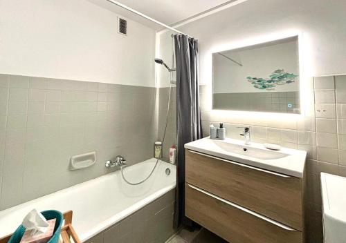ein Badezimmer mit einer Badewanne, einem Waschbecken und einer Badewanne in der Unterkunft T2 Le SunScène-Parking-Clim-Terrasses-Centre- CapitalChic Services in Cannes