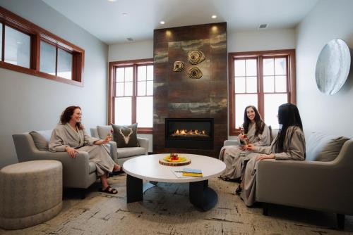 傑克遜的住宿－Snow King Resort Luxury Condominiums，三名妇女坐在带壁炉的客厅