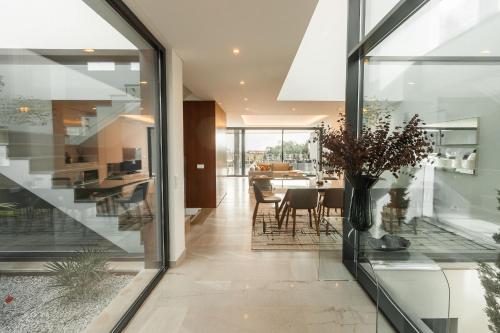 a living room and dining room with glass walls at Buganvilia - Luxury villa - private pool by HD in Vale Formoso