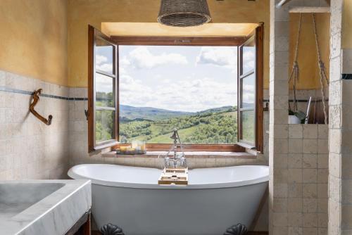 a bath tub in a bathroom with a window at Casa al Poggio and Chianti view in San Donato in Poggio