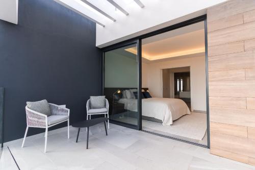 a bedroom with a bed and a glass wall at Buganvilia - Luxury villa - private pool by HD in Almancil