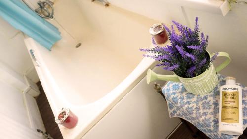 a bottle of soap and flowers in a vase on a shelf at Top Chiswick Apartments, London Center Area in London