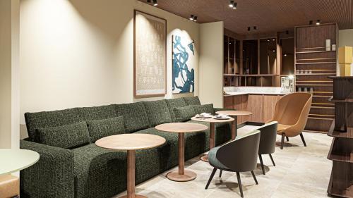 un soggiorno con divano verde e tavoli di Hôtel Gabbie a Parigi
