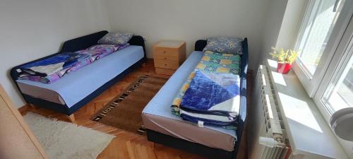 a bedroom with two beds and a window at Home Nikolić in Novi Pazar