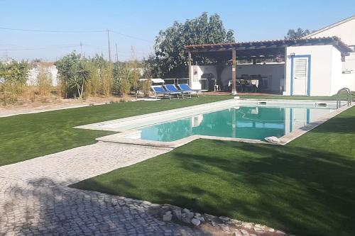 ein Schwimmbad in der Mitte eines Gartens in der Unterkunft Casa do Tié in Quinta do Anjo