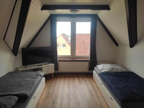 een kamer met 2 bedden, een tv en een raam bij Giraffe-1-4-Personen in Brunsbüttel