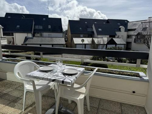un tavolo bianco e sedie su un balcone di Confortable studio, wifi, parking, proche plage a Carnac
