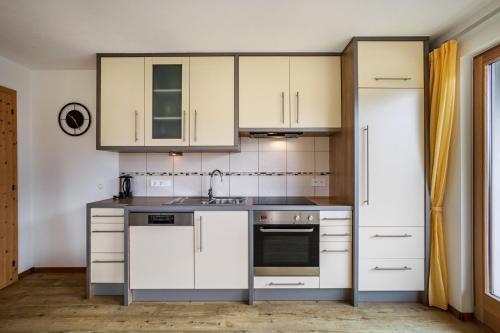a kitchen with white cabinets and a sink at Stoffnerhof Apt Sonnenblume in Tesido