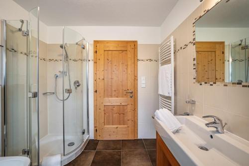 La salle de bains est pourvue d'une douche, d'une baignoire et d'un lavabo. dans l'établissement Stoffnerhof Apt Sonnenblume, à Monguelfo-Tesido