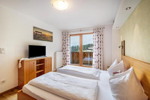 a hotel room with two beds and a window at Stoffnerhof Apt Sonnenblume in Tesido