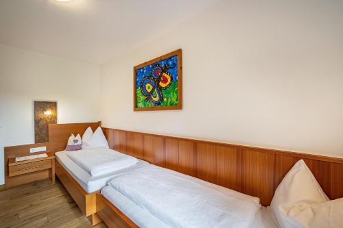 a bedroom with two beds and a painting on the wall at Stoffnerhof Apt Sonnenblume in Tesido