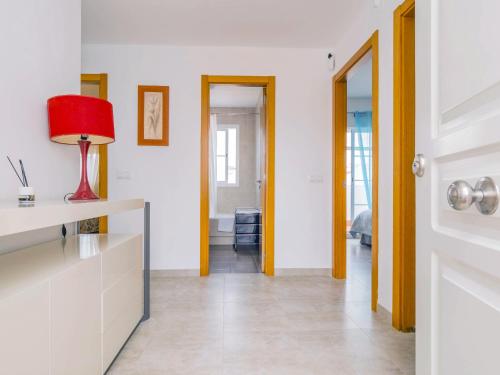 a living room with a red lamp and a hallway at Cubo's Casa Rural Daza in Almogía