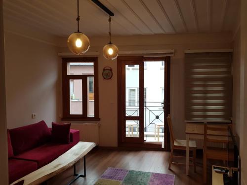 a living room with a red couch and some windows at Linden Houses in Istanbul