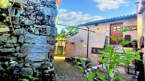 a stone building with a red door and a stone wall at Charming house in Lindoso with terrace and parking included in Lindoso