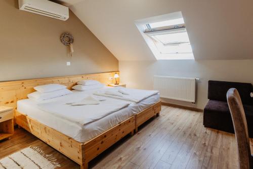 a bedroom with a large bed and a skylight at Kakukk Vendéglő Panzió in Bánd