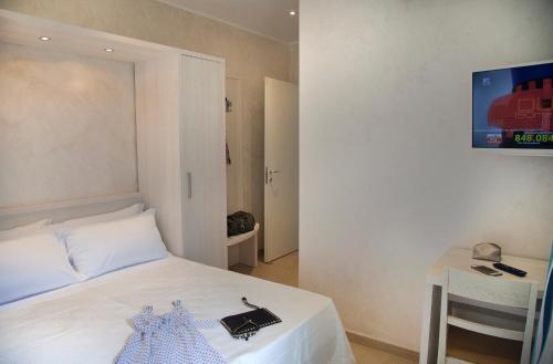 リミニにあるHotel Residence Maria Graziaのベッドルーム(ベッド1台、テーブル、テレビ付)
