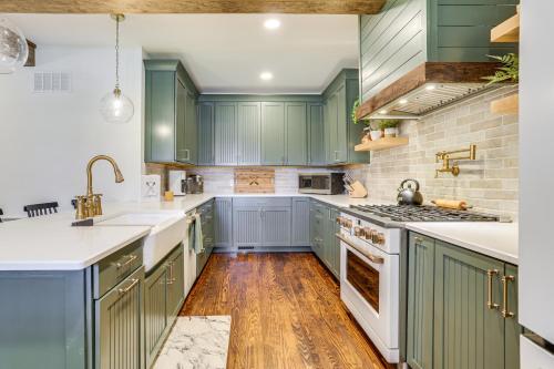 a kitchen with green cabinets and wooden floors at Hot Tub and Lake Access at Poconos Getaway! in Lake Ariel
