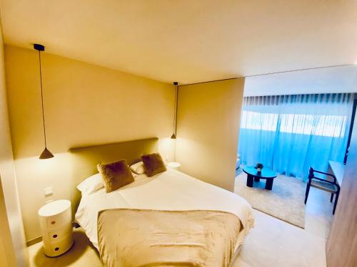 um quarto com uma cama e uma grande janela em Piscina con Glamour em Múrcia