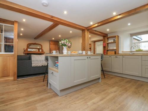 a kitchen with white cabinets and a counter top at Lime Tree Cottage in Kirkby Stephen
