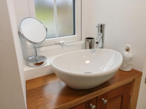 a bathroom with a white sink and a mirror at Lime Tree Cottage in Kirkby Stephen