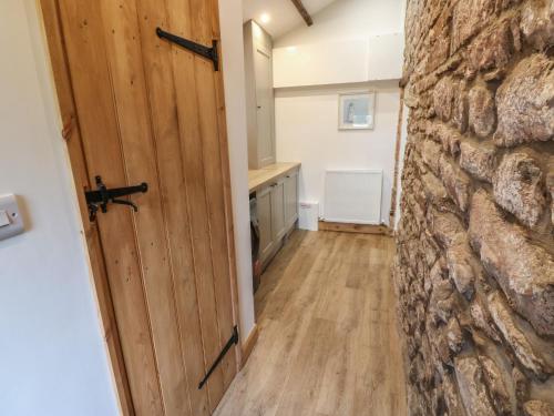 a hallway with a door and a stone wall at Lime Tree Cottage in Kirkby Stephen