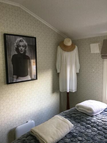 a bedroom with a bed and a dress hanging on a wall at Villa Skoglund in Stranda