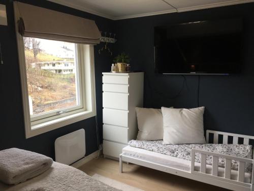 a bedroom with a white bed and a window at Villa Skoglund in Stranda