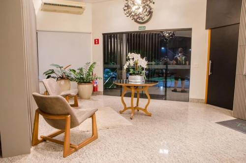 a lobby with a table and a chair and a table at Ville Park Hotel in Ourinhos