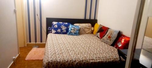 uma cama com almofadas num quarto em 1 Chambre Arena - La Chapelle em Paris