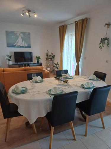 a dining room table with chairs and a couch at Josipa & Jelena Apartment in Senj