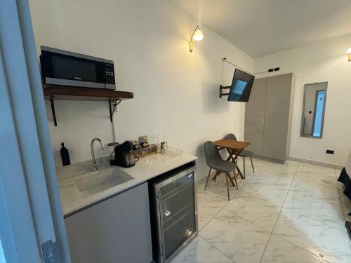 a kitchen with a sink and a tv on the wall at Apartaestudio la capital in San José