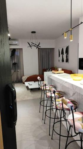 a living room with a bar with chairs and a kitchen at Rita's 2-BR Apt in Mar Mikhael in Beirut