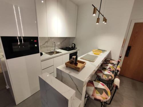 a kitchen with a counter with chairs and a sink at Rita's 2-BR Apt in Mar Mikhael in Beirut