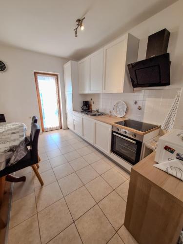 a kitchen with white cabinets and a stove top oven at Josipa & Jelena Apartment in Senj