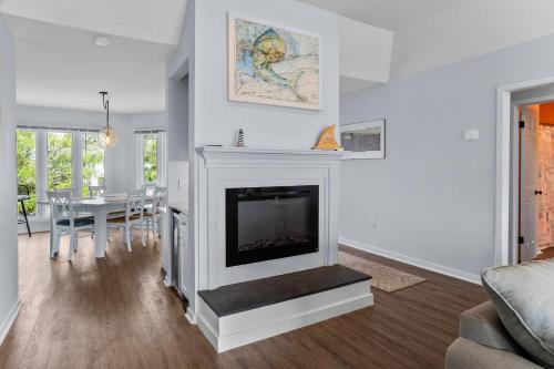 a living room with a fireplace and a table at Nautical Watch on Harbor Island in Oceanmarsh Subdivision