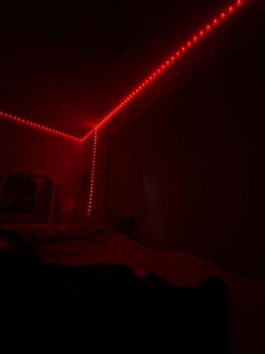 um quarto com uma cama com luzes vermelhas em SpicyGameRoom em La Paz